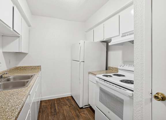 A kitchen with white appliances and cabinets.