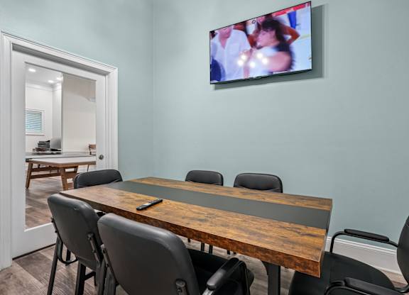A conference room with a large table and chairs.