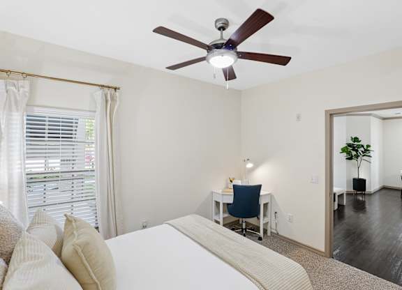 A bedroom with a bed, desk, and chair.