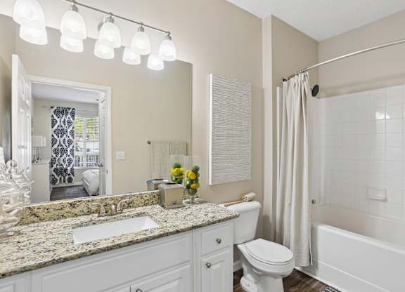 A bathroom with a white toilet, sink, and bathtub.