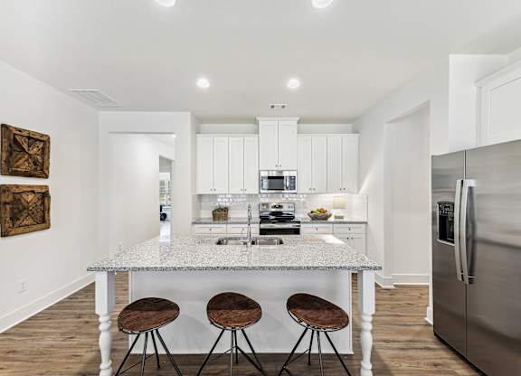 a kitchen with a marble counter top and three stools