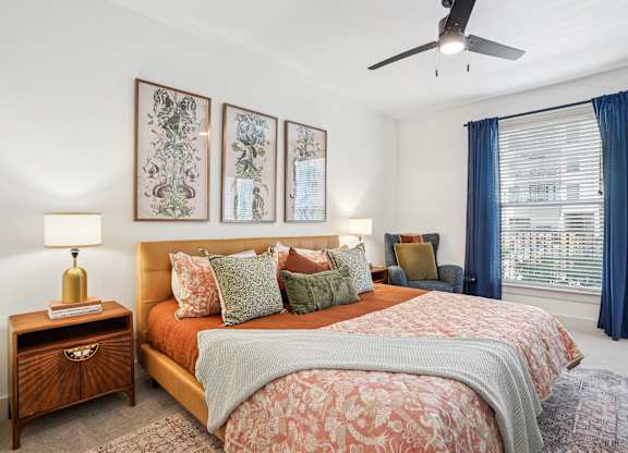 A bedroom with a large bed and a ceiling fan.