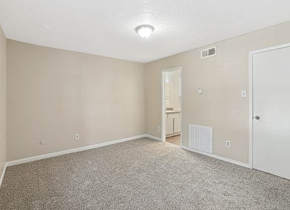 A room with a carpeted floor and a white door.