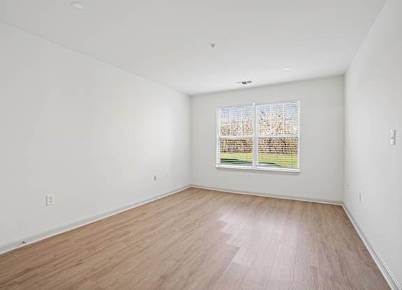 Empty room with wooden floor and a window.