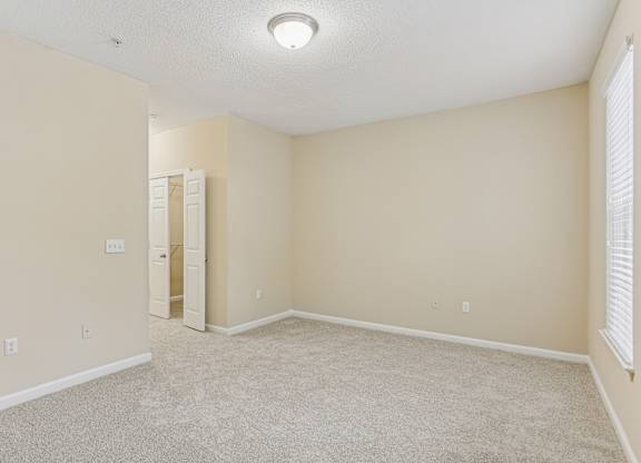 A room with a carpeted floor and a white ceiling light.
