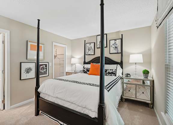 A bedroom with a four poster bed and a white bedspread.