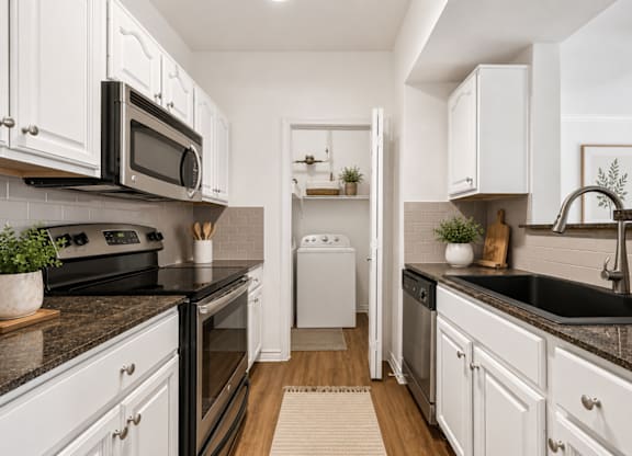 A modern kitchen with white cabinets at St Moritz in Dallas Texas