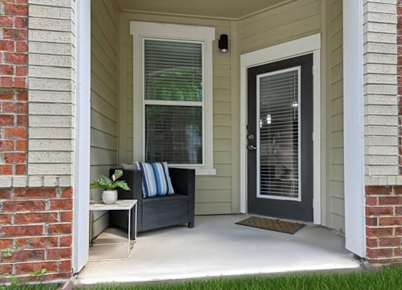 A house entrance with a bench and a door.