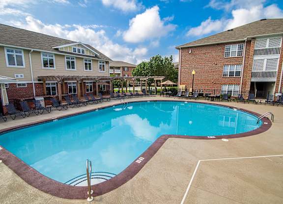 A swimming pool in a residential area surrounded by houses.