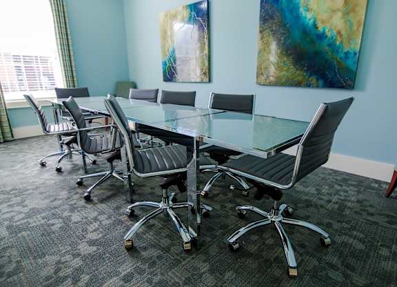 A conference room with a glass table and chairs.