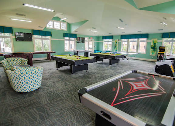 A billiards room with a pool table and a foosball table.