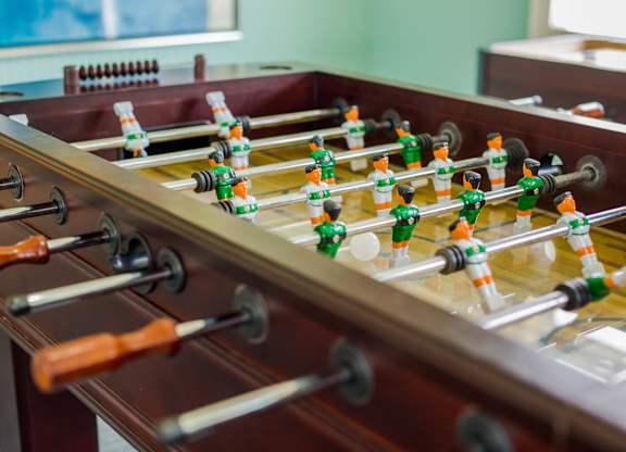 A foosball table with green and orange players.