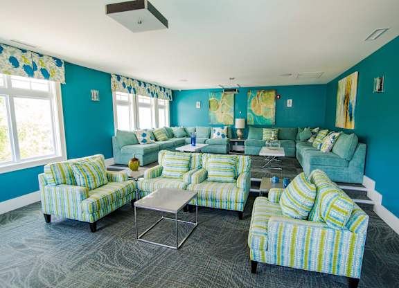 A living room with blue walls and striped chairs.