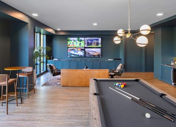 A room with a pool table and a television.