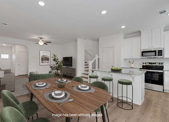 A modern kitchen with a dining table set for six.