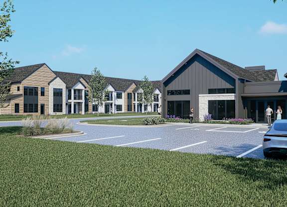 A modern building with a parking lot in front.