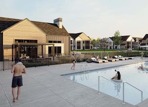 A group of people are enjoying a swimming pool in front of a house.