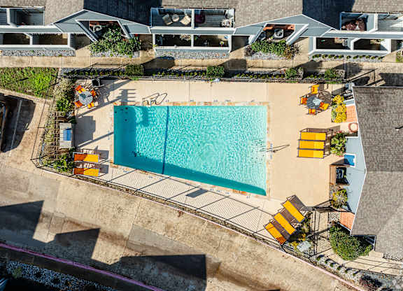A large swimming pool surrounded by yellow sun loungers.