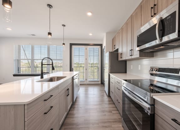 a large kitchen with white counter tops and wooden cabinets
