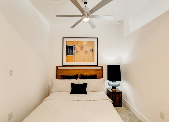 a bedroom with a bed and a ceiling fan