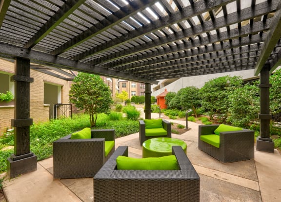 a pergola with a fire pit in the middle of a courtyard