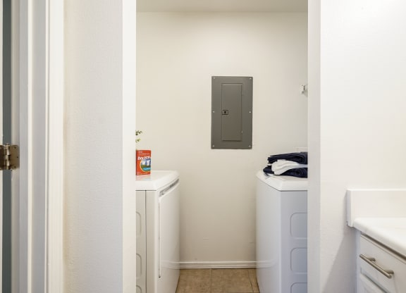 a laundry room with two washers and two dryers