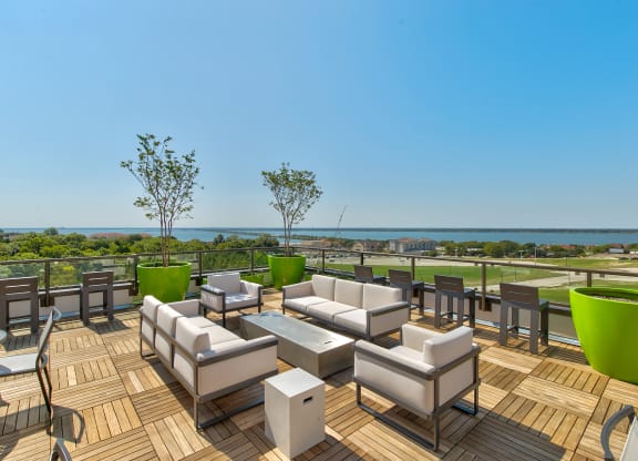 a large deck with couches and tables overlooking the ocean