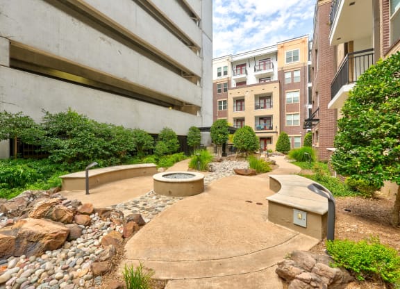 an outdoor area with benches and rocks and plants