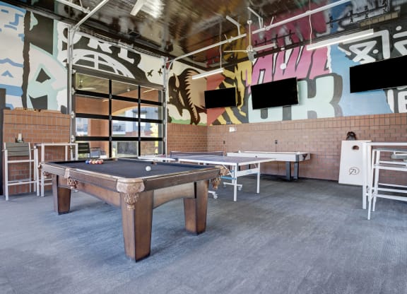 a games room with a pool table and tables