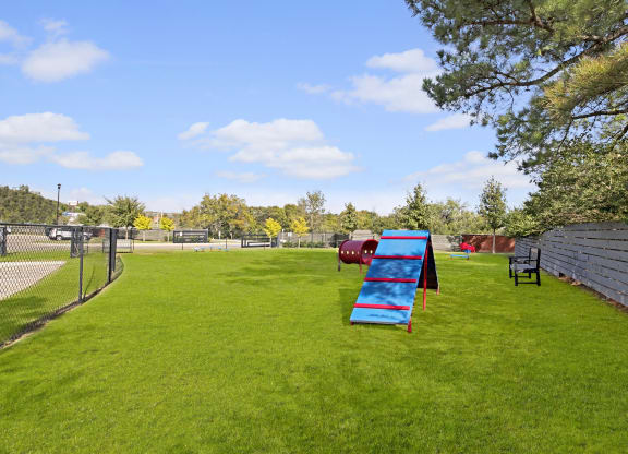 a playground with a blue bench in the middle of a field