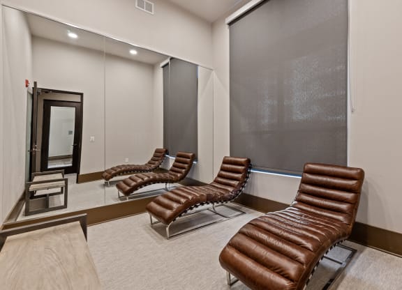 a private screening room with leather chairs in front of a mirror
