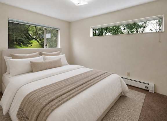 A bedroom with a large bed and a window.