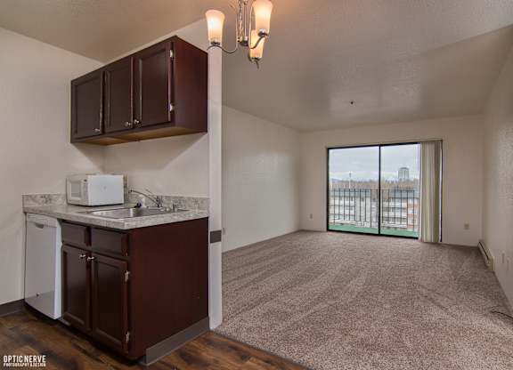 A kitchen area with brown cabinets and a white dishwasher.