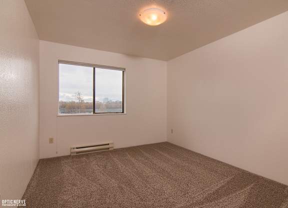 A room with carpeted floor and a window overlooking a body of water.