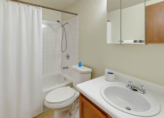 A white toilet sits next to a white sink in a bathroom.