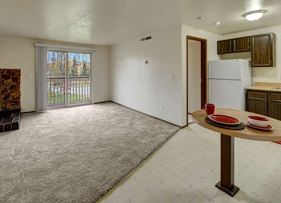 A room with a table and chairs and a refrigerator.