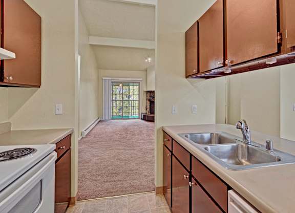 A kitchen with brown cabinets and a white stove top oven.