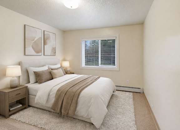 A bedroom with a bed, nightstand, and two framed pictures on the wall.