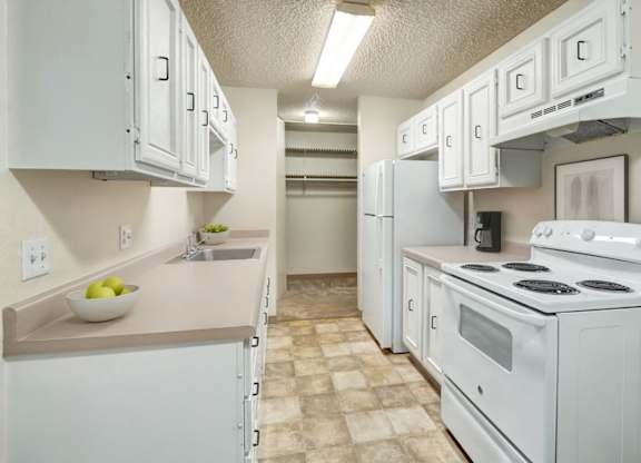 A kitchen with white appliances and cabinets.