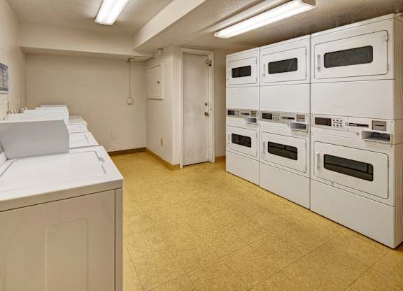A row of white ovens are lined up in a room.
