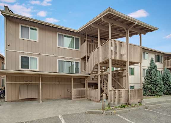 A large two-story residential building with a balcony and a staircase.