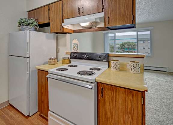 A kitchen with a white refrigerator and a white stove top oven.