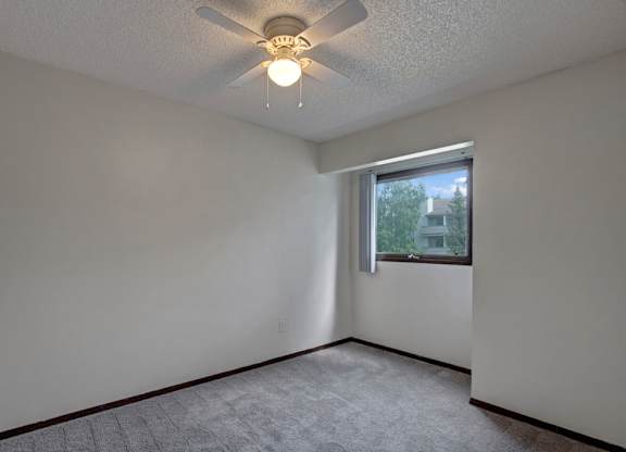 A room with a ceiling fan and a window.