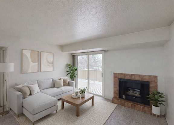 A living room with a grey couch, a fireplace, and a plant.