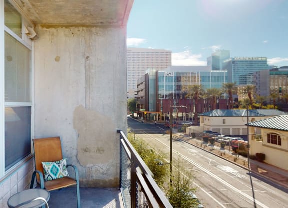 a balcony with a chair and a view of the city