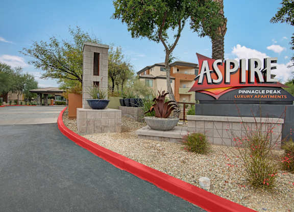 The image shows a sign for Aspire Pinnacle Peak Luxury Apartments.