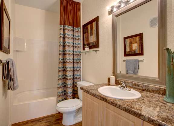 A bathroom with a toilet, sink, and shower.