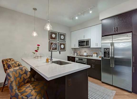 A modern kitchen with a white countertop and a patterned chair.