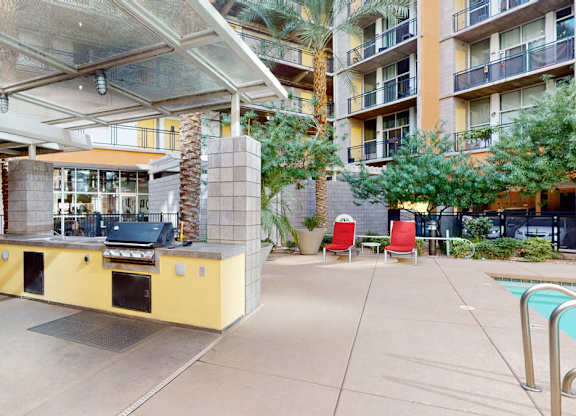 A patio area with a pool and a barbecue grill.
