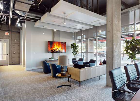 A modern waiting room with a fireplace and comfortable seating.